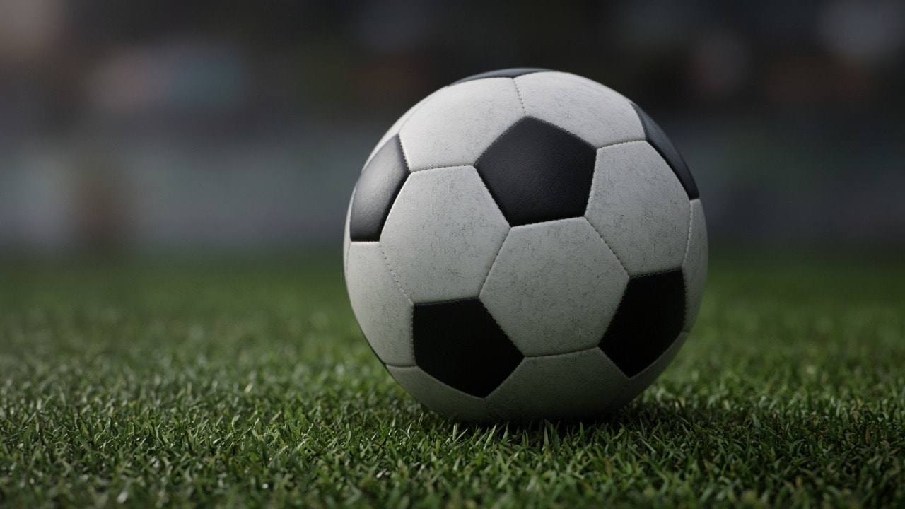 Balón de fútbol en el césped de un estadio